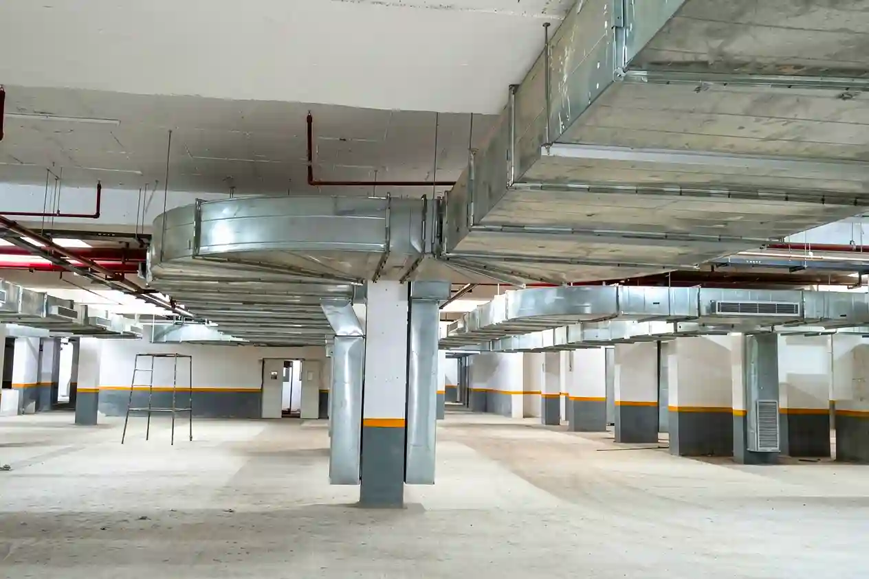 Overhead rectangular exhaust ductwork for basement smoke extraction and air circulation.