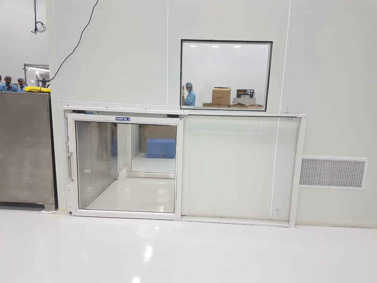Cleanroom pass-through chamber with sliding glass door for sterile material transfer.